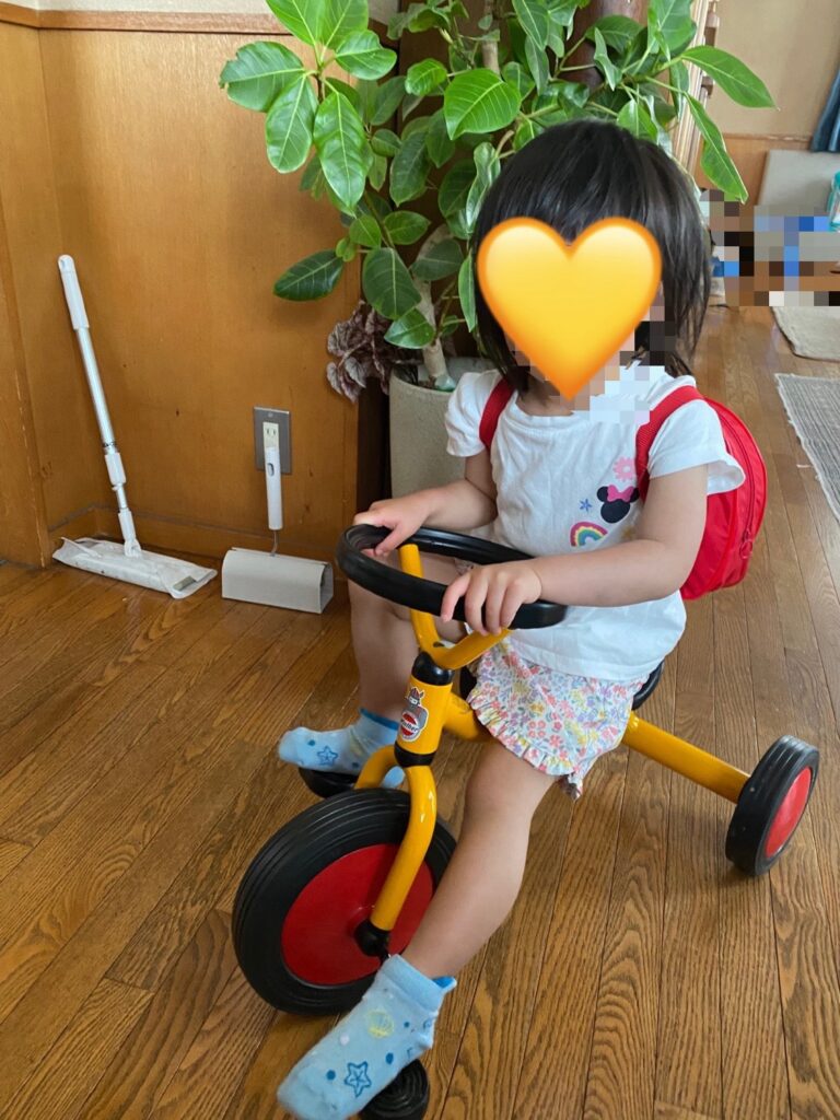 子どもが三輪車に乗っている